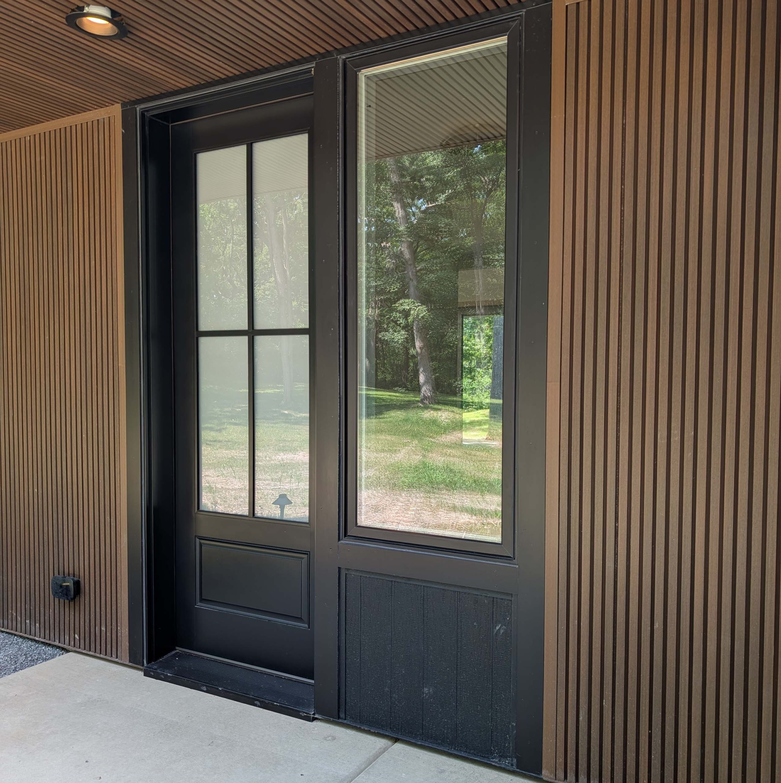 Modern residential front door with large translucent glass and a side window with black trim