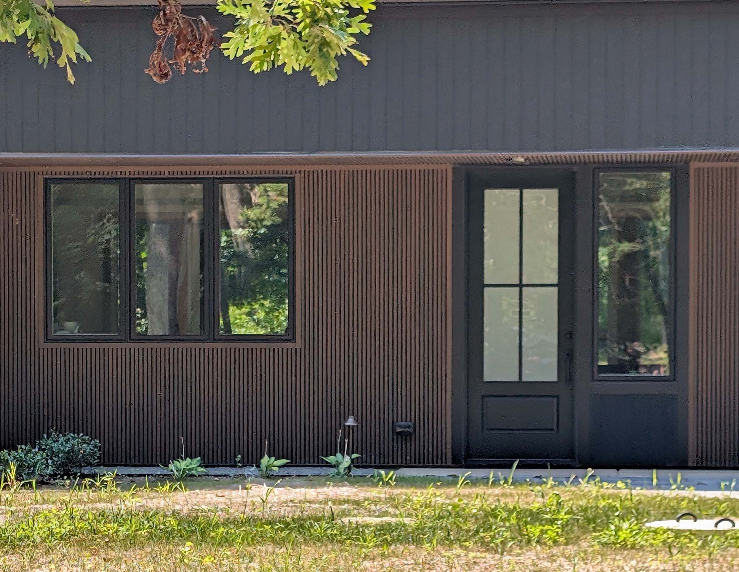 Modern residential front door with large translucent glass and a side window with black trim